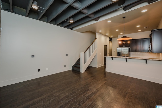 unfurnished living room with dark wood-type flooring and a chandelier