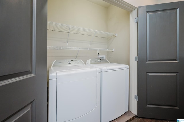 laundry area featuring dark wood-type flooring and washing machine and clothes dryer