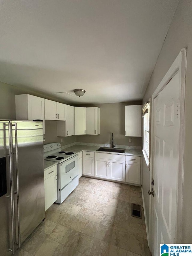 kitchen with stainless steel refrigerator with ice dispenser, white cabinets, sink, and white range with electric cooktop