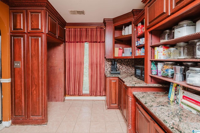 interior space with tasteful backsplash, light stone countertops, and light tile patterned floors