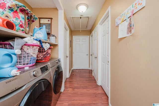 clothes washing area featuring washer and dryer, hardwood / wood-style flooring, and a textured ceiling