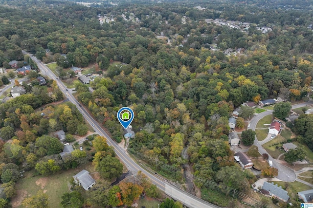 aerial view of property and surrounding area with a heavily wooded area