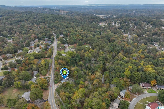 aerial view of property and surrounding area featuring a forest