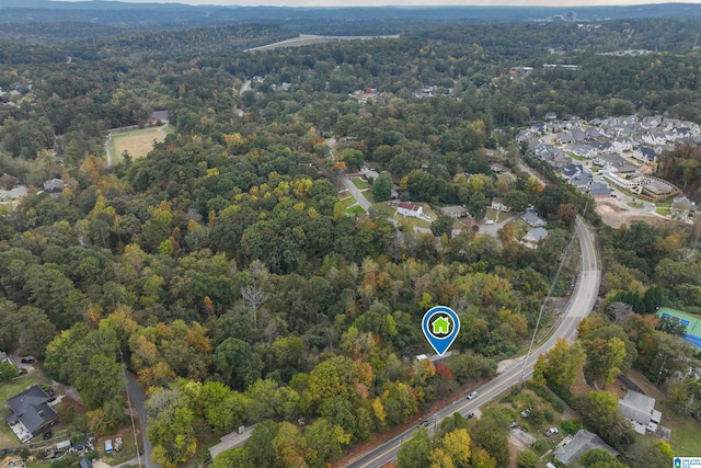 aerial view of property and surrounding area featuring a heavily wooded area