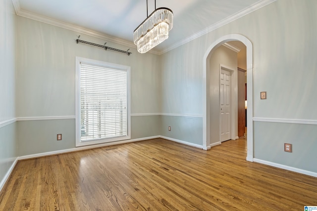 unfurnished room featuring crown molding, a chandelier, and light wood-type flooring