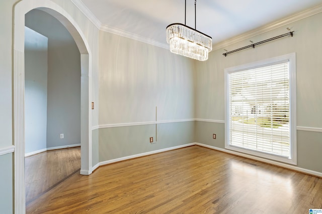 unfurnished room with light hardwood / wood-style flooring, ornamental molding, and a notable chandelier