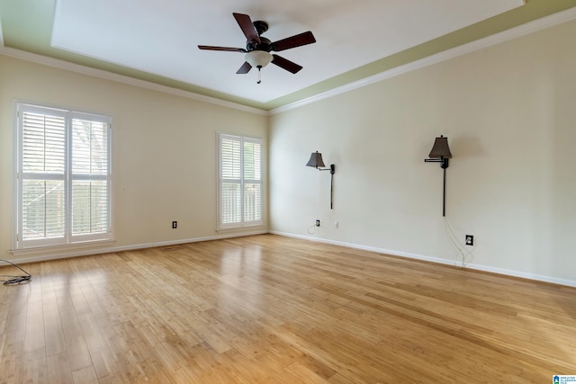 empty room with light wood-type flooring, plenty of natural light, and ornamental molding