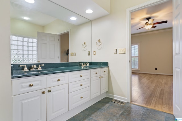 bathroom featuring a wealth of natural light, hardwood / wood-style floors, vanity, and ornamental molding