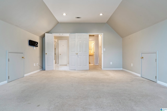 additional living space with light carpet and vaulted ceiling