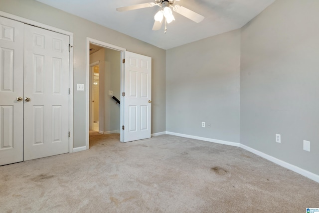 unfurnished bedroom featuring ceiling fan, a closet, and light carpet