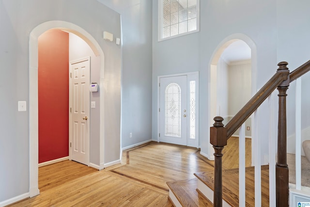 foyer entrance featuring a high ceiling and light hardwood / wood-style flooring