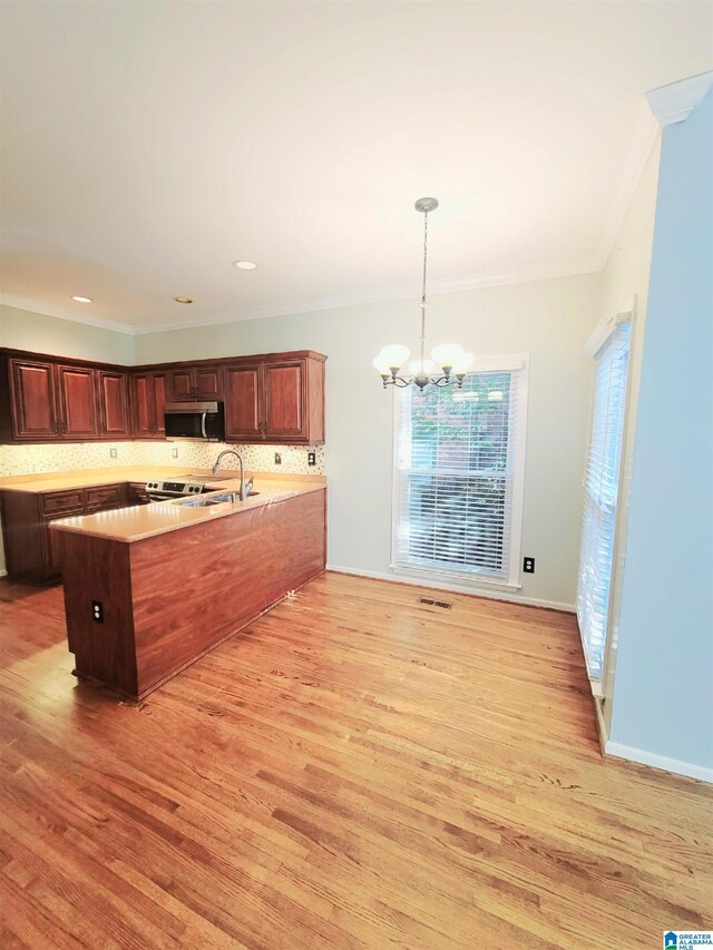 kitchen with backsplash, crown molding, hanging light fixtures, light hardwood / wood-style flooring, and a notable chandelier