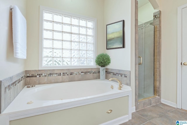 bathroom featuring a bath, a shower stall, and plenty of natural light