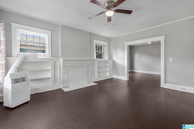 unfurnished room featuring ceiling fan, built in shelves, a fireplace, and dark hardwood / wood-style flooring