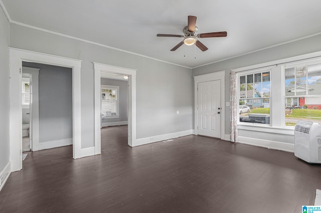 empty room featuring ornamental molding, dark wood-type flooring, and ceiling fan