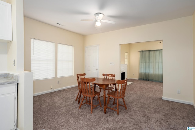 carpeted dining room with ceiling fan