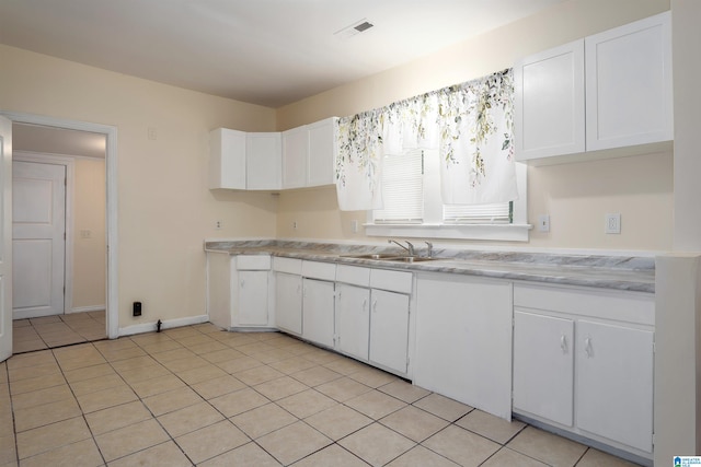 kitchen with sink, white cabinetry, and light tile patterned floors