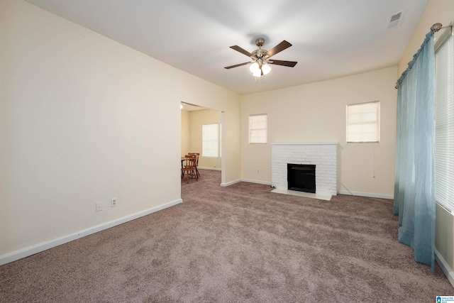 unfurnished living room with carpet, a fireplace, and ceiling fan