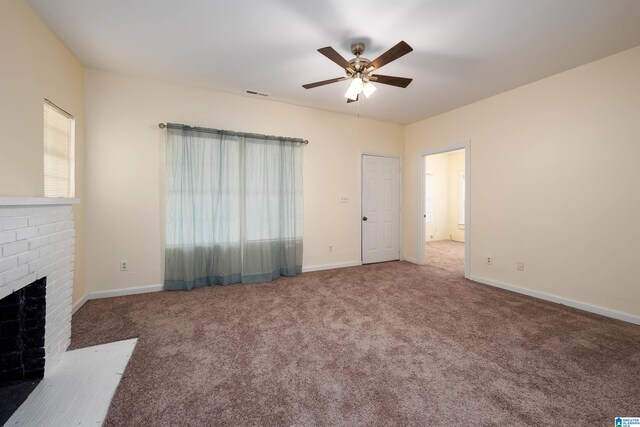 unfurnished living room featuring ceiling fan, carpet flooring, and a brick fireplace