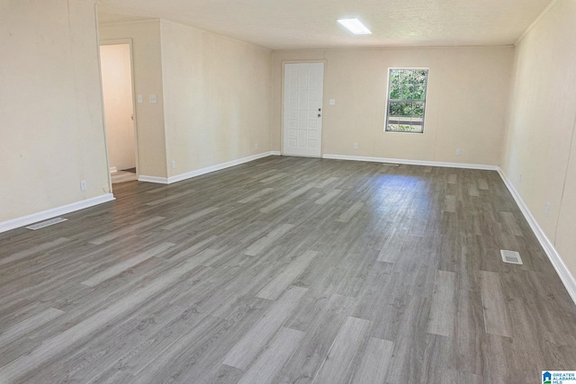 empty room featuring a textured ceiling and hardwood / wood-style flooring