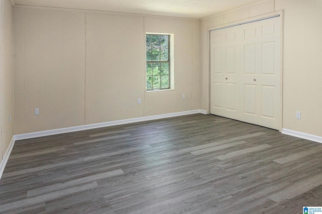 unfurnished bedroom featuring crown molding and dark hardwood / wood-style flooring