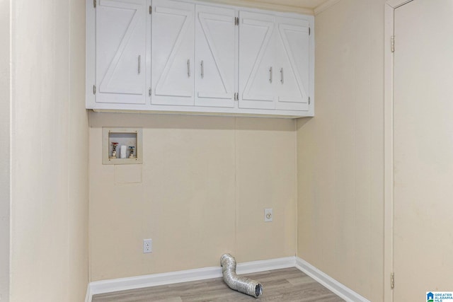 clothes washing area featuring electric dryer hookup, washer hookup, light wood-type flooring, and cabinets