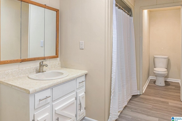 bathroom featuring vanity, wood-type flooring, and toilet