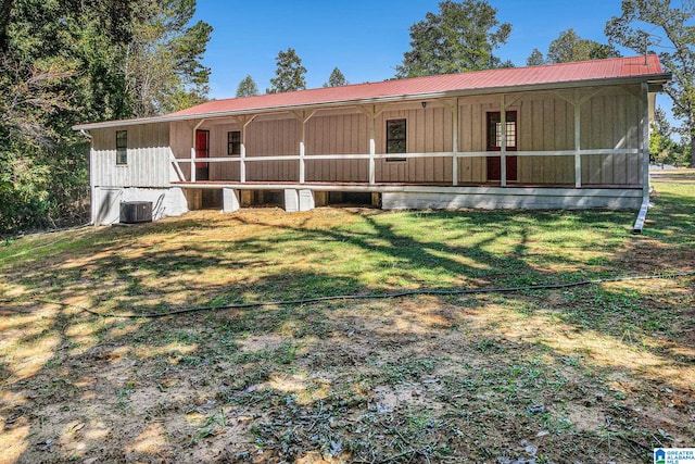 view of front of property with a front yard, central air condition unit, and a sunroom