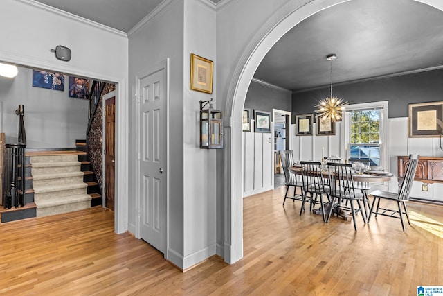 dining room featuring light hardwood / wood-style flooring, crown molding, and a chandelier