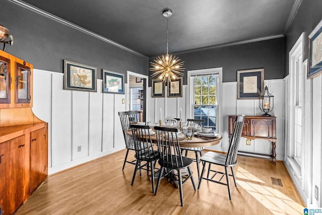 dining room featuring ornamental molding, light hardwood / wood-style floors, and a chandelier