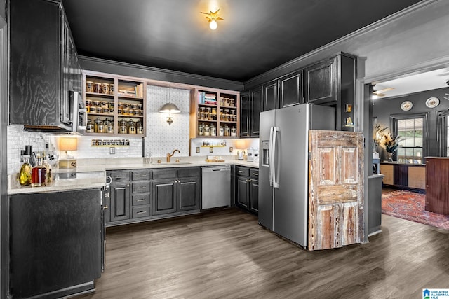 kitchen featuring stainless steel appliances, dark hardwood / wood-style floors, sink, decorative light fixtures, and tasteful backsplash