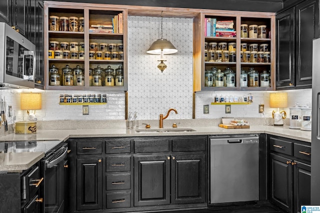 kitchen with appliances with stainless steel finishes, light stone countertops, sink, decorative light fixtures, and tasteful backsplash