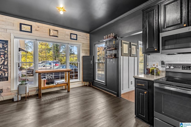 kitchen with appliances with stainless steel finishes, crown molding, and dark hardwood / wood-style floors