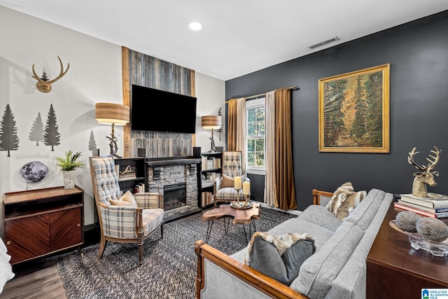 living room with hardwood / wood-style flooring and a stone fireplace