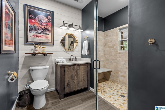 bathroom featuring vanity, hardwood / wood-style floors, a shower with shower door, and toilet