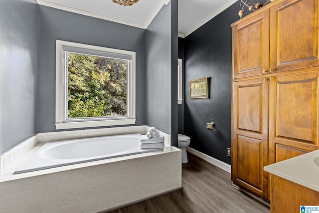 bathroom with ornamental molding, hardwood / wood-style flooring, tiled bath, and toilet