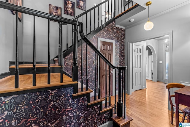 staircase with crown molding and hardwood / wood-style floors