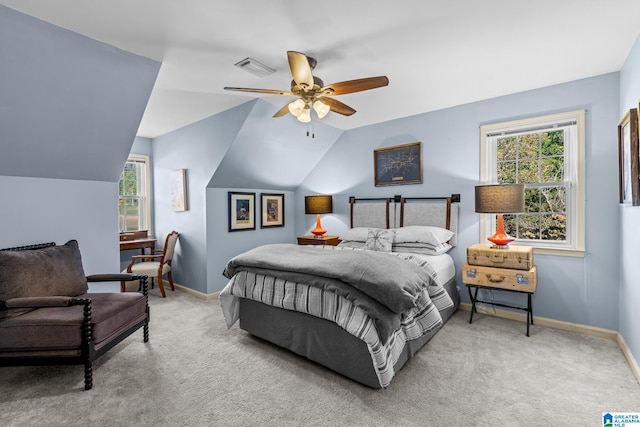 bedroom with vaulted ceiling, light colored carpet, ceiling fan, and multiple windows