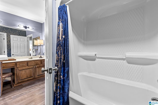 bathroom with wood-type flooring, vanity, and shower / bathtub combination with curtain