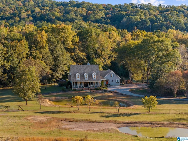 exterior space with a porch, a front yard, a rural view, and a water view