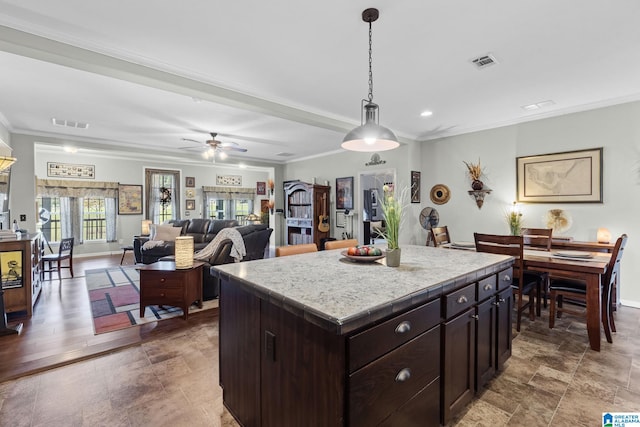 kitchen with ceiling fan, crown molding, hanging light fixtures, and a center island