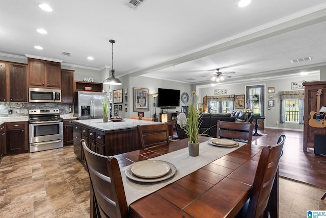 dining area with ceiling fan and ornamental molding