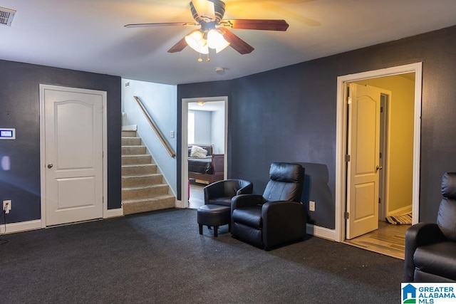 living area featuring dark wood-type flooring and ceiling fan