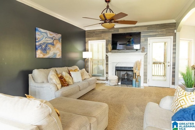 carpeted living room with crown molding and ceiling fan