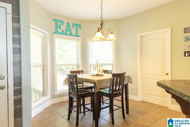 dining space with a notable chandelier and light tile patterned flooring