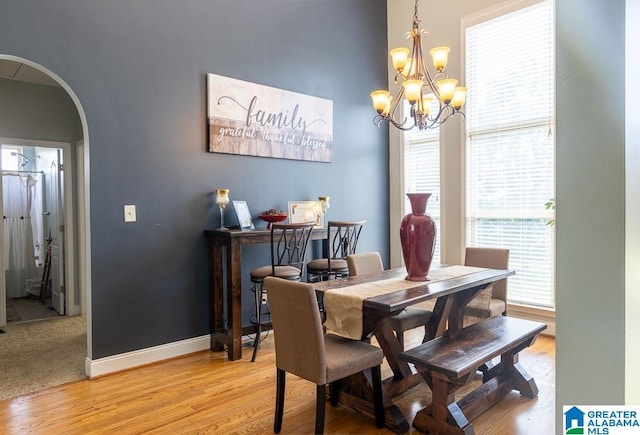 dining area with a wealth of natural light, a chandelier, and light hardwood / wood-style floors