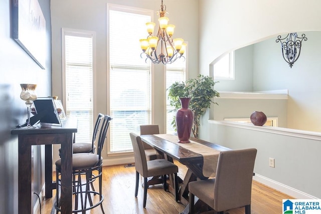 dining area featuring an inviting chandelier, plenty of natural light, and light wood-type flooring