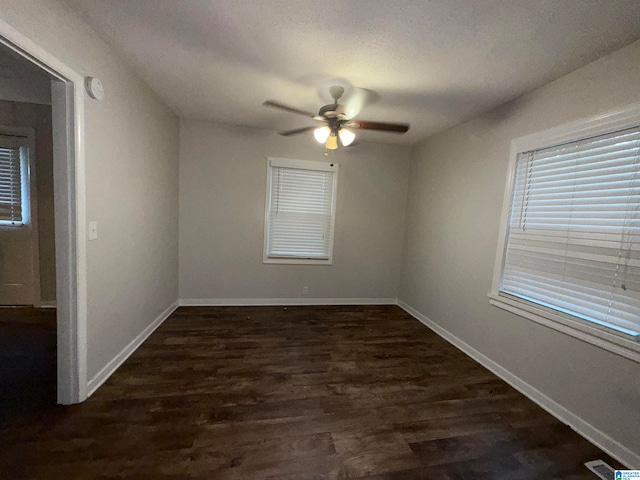 empty room featuring dark wood-type flooring and ceiling fan