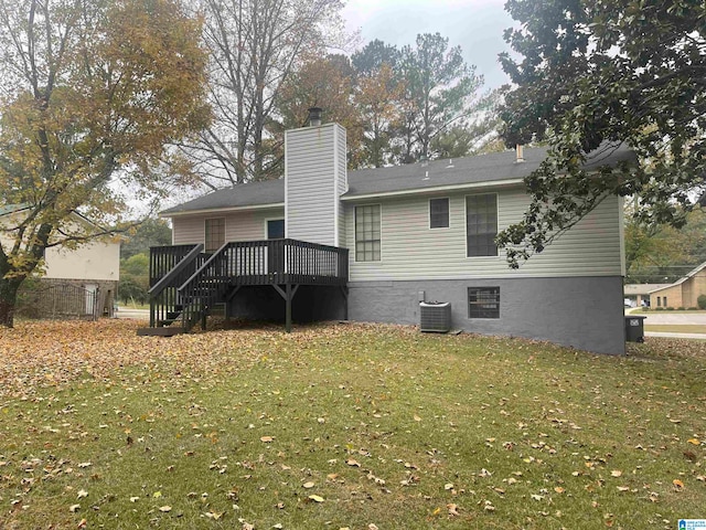 rear view of house with central air condition unit, a deck, and a yard