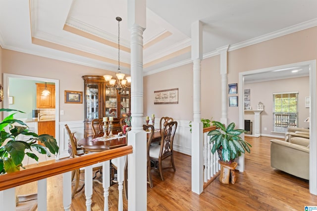 dining room featuring hardwood / wood-style flooring, a chandelier, crown molding, and a tray ceiling